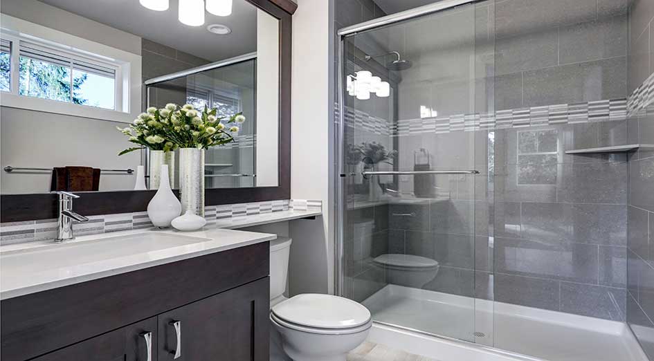 grey bathroom with toilet, mirror and shower