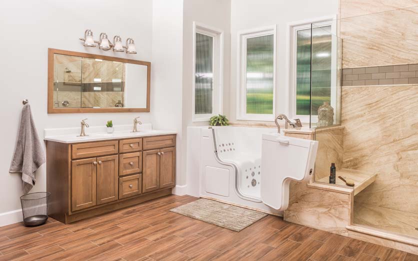 walk in bathtub with open door and view of the cabinet and mirror on the left side