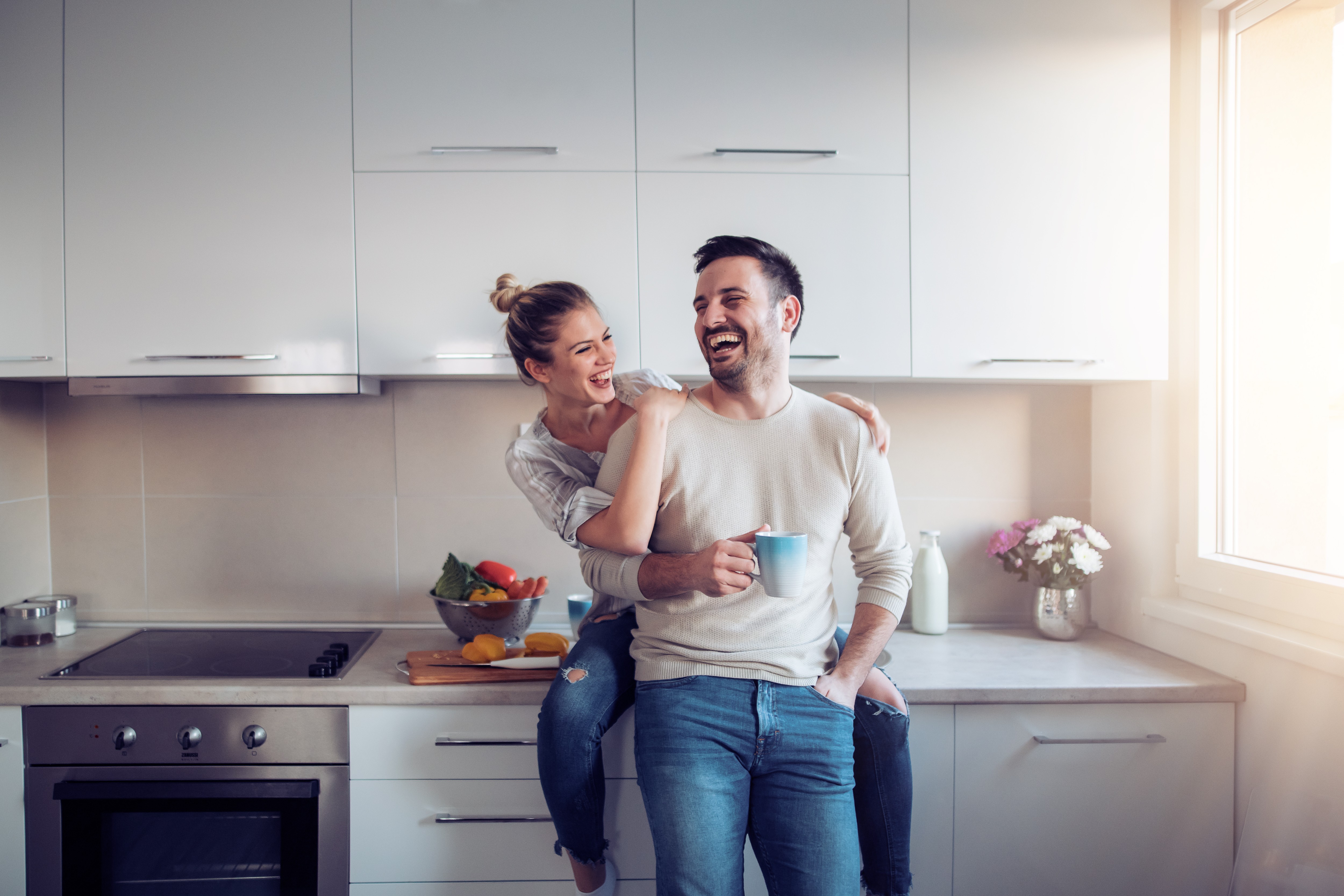 A couple laughing in the kitchen