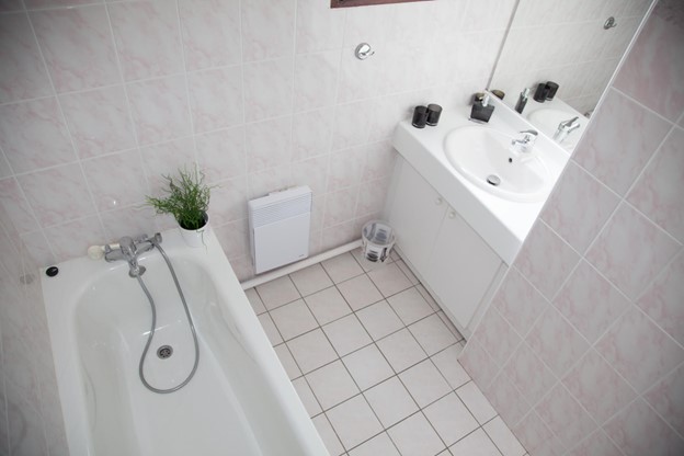 A small bathroom with a sink and a bathtub