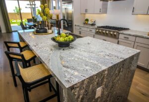 A kitchen with a marble countertop island